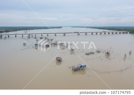 Aerial view of fishing trap net in canel with fisherman urban city village town houses, lake or river. Nature landscape fisheries and fishing tools at Pak Pha, Songkhla, Thailand. Aquaculture farming Aerial view of fishing trap net in canel with fisherman urban city village town houses, lake or river. Nature landscape fisheries and fishing tools at Pak Pha, Songkhla, Thailand. Aquaculture farming 107174795