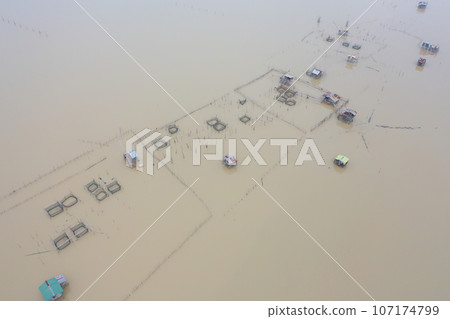 Aerial view of fishing trap net in canel with fisherman urban city village town houses, lake or river. Nature landscape fisheries and fishing tools at Pak Pha, Songkhla, Thailand. Aquaculture farming Aerial view of fishing trap net in canel with fisherman urban city village town houses, lake or river. Nature landscape fisheries and fishing tools at Pak Pha, Songkhla, Thailand. Aquaculture farming 107174799