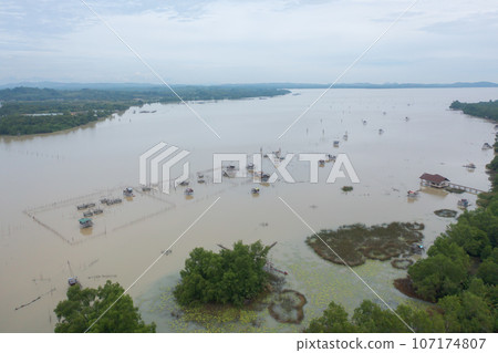 Aerial view of fishing trap net in canel with fisherman urban city village town houses, lake or river. Nature landscape fisheries and fishing tools at Pak Pha, Songkhla, Thailand. Aquaculture farming Aerial view of fishing trap net in canel with fisherman urban city village town houses, lake or river. Nature landscape fisheries and fishing tools at Pak Pha, Songkhla, Thailand. Aquaculture farming 107174807