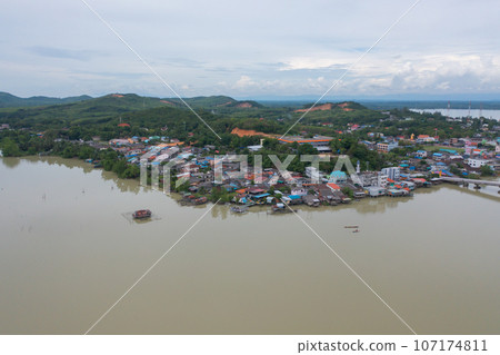 Aerial view of fishing trap net in canel with fisherman urban city village town houses, lake or river. Nature landscape fisheries and fishing tools at Pak Pha, Songkhla, Thailand. Aquaculture farming Aerial view of fishing trap net in canel with fisherman urban city village town houses, lake or river. Nature landscape fisheries and fishing tools at Pak Pha, Songkhla, Thailand. Aquaculture farming 107174811