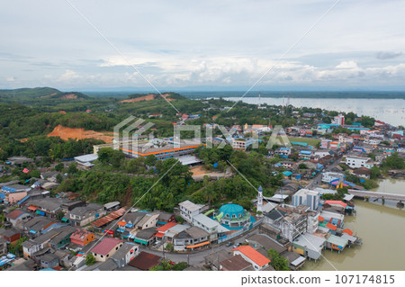 Aerial view of fishing trap net in canel with fisherman urban city village town houses, lake or river. Nature landscape fisheries and fishing tools at Pak Pha, Songkhla, Thailand. Aquaculture farming Aerial view of fishing trap net in canel with fisherman urban city village town houses, lake or river. Nature landscape fisheries and fishing tools at Pak Pha, Songkhla, Thailand. Aquaculture farming 107174815