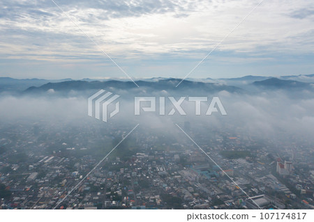 Aerial view of residential neighborhood roofs with fog mist in rainy season. Urban housing development from above. Top view. Real estate in Phuket, southern province city, Thailand. 107174817