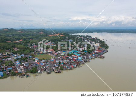 Aerial view of fishing trap net in canel with fisherman urban city village town houses, lake or river. Nature landscape fisheries and fishing tools at Pak Pha, Songkhla, Thailand. Aquaculture farming Aerial view of fishing trap net in canel with fisherman urban city village town houses, lake or river. Nature landscape fisheries and fishing tools at Pak Pha, Songkhla, Thailand. Aquaculture farming 107174827