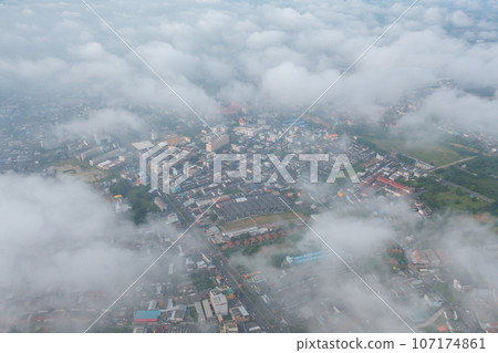 Aerial view of residential neighborhood roofs with fog mist in rainy season. Urban housing development from above. Top view. Real estate in Phuket, southern province city, Thailand. Aerial view of residential neighborhood roofs with fog mist in rainy season. Urban housing development from above. Top view. Real estate in Phuket, southern province city, Thailand. 107174861