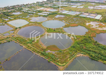 Aerial view of natural sea salt ponds, lake or sea. Farm field outdoor in traditional industry in Thailand. Asia culture. Agriculture irrigation. River reflection. 107174912