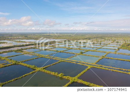 Aerial view of natural sea salt ponds, lake or sea. Farm field outdoor in traditional industry in Thailand. Asia culture. Agriculture irrigation. River reflection. 107174941