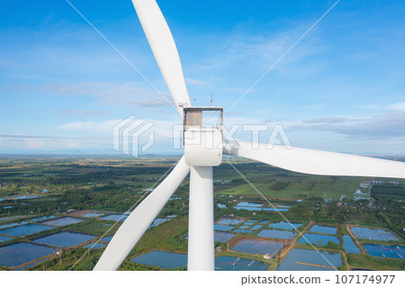 Aerial view of wind turbines or windmills farm field and sea shore beach in industry factory. water power, sustainable green clean energy, and environment concept. Nature innovation. Aerial view of wind turbines or windmills farm field and sea shore beach in industry factory. water power, sustainable green clean energy, and environment concept. Nature innovation. 107174977