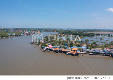 Aerial view of fishing trap net in canel with fisherman urban city village town houses, lake or river. Nature landscape fisheries and fishing tools at Pak Pha, Songkhla, Thailand. Aquaculture farming Aerial view of fishing trap net in canel with fisherman urban city village town houses, lake or river. Nature landscape fisheries and fishing tools at Pak Pha, Songkhla, Thailand. Aquaculture farming 107175425