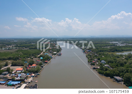 Aerial view of fishing trap net in canel with fisherman urban city village town houses, lake or river. Nature landscape fisheries and fishing tools at Pak Pha, Songkhla, Thailand. Aquaculture farming 107175459