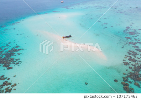 Aerial view of boats with clear blue separated island, turquoise seawater, Andaman sea in Phuket island in summer season, Thailand. Water in ocean material pattern texture wallpaper background. Aerial view of boats with clear blue separated island, turquoise seawater, Andaman sea in Phuket island in summer season, Thailand. Water in ocean material pattern texture wallpaper background. 107175462