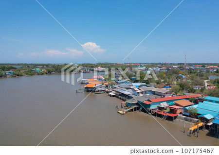 Aerial view of fishing trap net in canel with fisherman urban city village town houses, lake or river. Nature landscape fisheries and fishing tools at Pak Pha, Songkhla, Thailand. Aquaculture farming 107175467