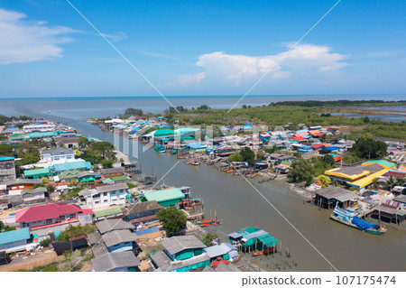 Aerial view of fishing trap net in canel with fisherman urban city village town houses, lake or river. Nature landscape fisheries and fishing tools at Pak Pha, Songkhla, Thailand. Aquaculture farming 107175474