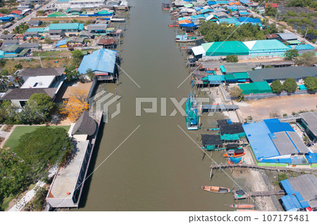 Aerial view of fishing trap net in canel with fisherman urban city village town houses, lake or river. Nature landscape fisheries and fishing tools at Pak Pha, Songkhla, Thailand. Aquaculture farming 107175481