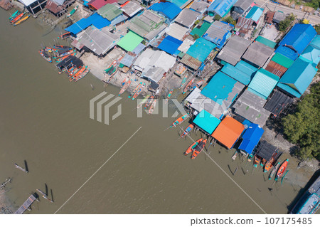 Aerial view of fishing trap net in canel with fisherman urban city village town houses, lake or river. Nature landscape fisheries and fishing tools at Pak Pha, Songkhla, Thailand. Aquaculture farming 107175485