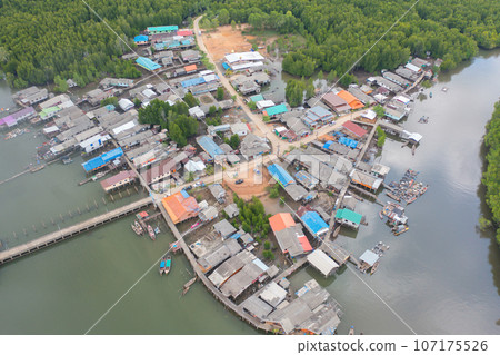 Aerial view of fishing trap net in canel with fisherman urban city village town houses, lake or river. Nature landscape fisheries and fishing tools at Pak Pha, Songkhla, Thailand. Aquaculture farming Aerial view of fishing trap net in canel with fisherman urban city village town houses, lake or river. Nature landscape fisheries and fishing tools at Pak Pha, Songkhla, Thailand. Aquaculture farming 107175526