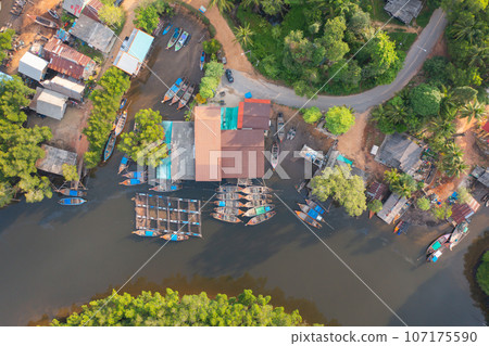 Aerial view of fishing trap net in canel with fisherman urban city village town houses, lake or river. Nature landscape fisheries and fishing tools at Pak Pha, Songkhla, Thailand. Aquaculture farming Aerial view of fishing trap net in canel with fisherman urban city village town houses, lake or river. Nature landscape fisheries and fishing tools at Pak Pha, Songkhla, Thailand. Aquaculture farming 107175590