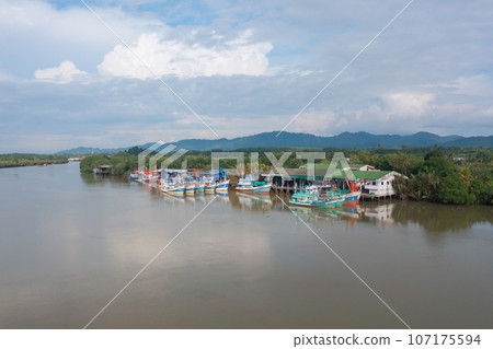 Aerial view of fishing trap net in canel with fisherman urban city village town houses, lake or river. Nature landscape fisheries and fishing tools at Pak Pha, Songkhla, Thailand. Aquaculture farming Aerial view of fishing trap net in canel with fisherman urban city village town houses, lake or river. Nature landscape fisheries and fishing tools at Pak Pha, Songkhla, Thailand. Aquaculture farming 107175594