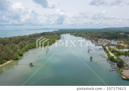 Aerial view of fishing trap net in canel with fisherman urban city village town houses, lake or river. Nature landscape fisheries and fishing tools at Pak Pha, Songkhla, Thailand. Aquaculture farming Aerial view of fishing trap net in canel with fisherman urban city village town houses, lake or river. Nature landscape fisheries and fishing tools at Pak Pha, Songkhla, Thailand. Aquaculture farming 107175623