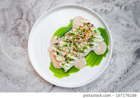 Shrimp tartare with sesame sauce and wasabi cream on a white plate 107176286