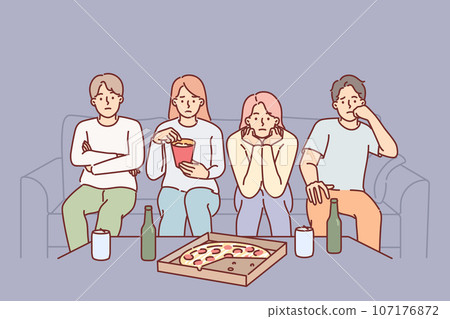People watch boring movie sitting on couch eating snacks during pizza party with college friends People watch boring movie sitting on couch eating snacks during pizza party with college friends 107176872