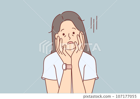 Tired woman with exhausted appearance touches face with hands and suffers from lack of motivation Tired woman with exhausted appearance touches face with hands and suffers from lack of motivation 107177055