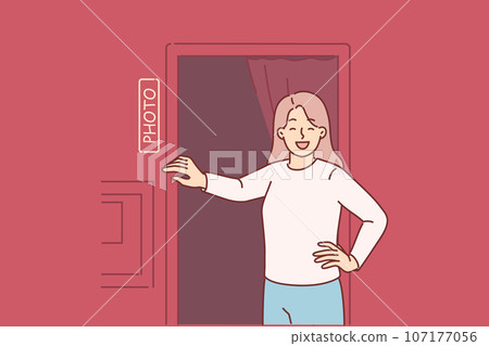 Woman stands near photo booth and laughs, feeling surge of positive emotions before photoshoot 107177056
