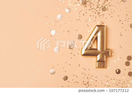 Gold candle in the form of number four. 107177212