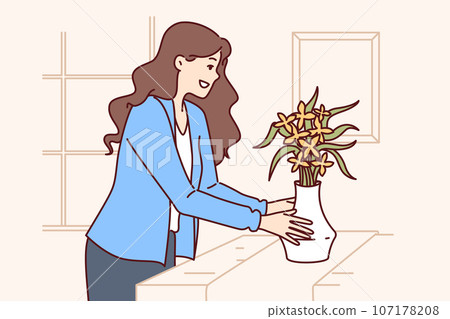 Woman does home staging and puts vase of flowers on table to prepare apartment for sale or rent 107178208