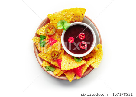 Spicy nachos. Mexican nacho chips, overhead flat lay shot with bbq sauce Spicy nachos. Mexican nacho chips, overhead flat lay shot with bbq sauce 107178531