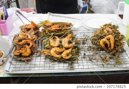 King prawns fried in batter, srimps prawn tempura on street market in Phuket, Thailand King prawns fried in batter, srimps prawn tempura on street market in Phuket, Thailand 107178825