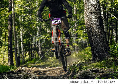 athlete mountainbiker downhill forest trail, racing DH mountain bike, extreme sport games 107180426