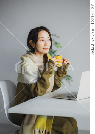 Woman drinking coffee and watching computer 107182127