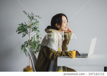 Woman drinking coffee and watching computer 107182132