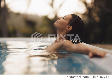 Tropical Luxury Relaxation of Beach Woman in Infinity Pool Tropical Luxury Relaxation of Beach Woman in Infinity Pool 107182715