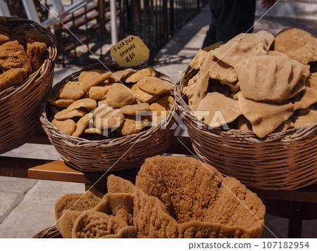 Wicker baskets filled with natural greek sponges at the gift shop, Symi island, Rhodes, Greece. 107182954