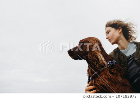 Portrait of a young woman with her dog. 107182972