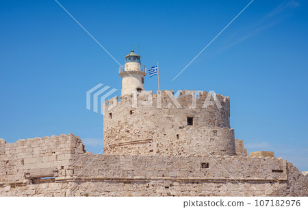 Mandraki port and fort of St. Nicholas. Rhodes, Greece. Hirschkuh statue in the place of the Colossus of Rhodes, Rhodes, Greece travel in summer sunny day Mandraki port and fort of St. Nicholas. Rhodes, Greece. Hirschkuh statue in the place of the Colossus of Rhodes, Rhodes, Greece travel in summer sunny day 107182976