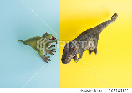 2 dinosaurs fighting on a yellow and blue background 2 dinosaurs fighting on a yellow and blue background 107185313