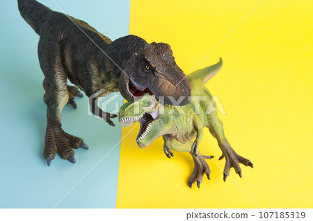 2 dinosaurs fighting on a yellow and blue background 2 dinosaurs fighting on a yellow and blue background 107185319