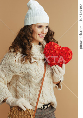 smiling stylish woman in beige sweater, mittens and hat smiling stylish woman in beige sweater, mittens and hat 107185462