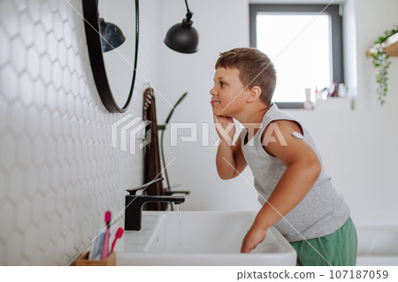 The diabetic boy getting ready in the morning, while wearing a continuous glucose monitoring sensor on his arm. The diabetic boy getting ready in the morning, while wearing a continuous glucose monitoring sensor on his arm. 107187059