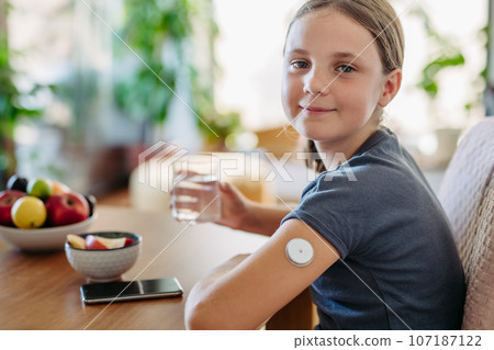 Close up of continuous glucose monitor sensor on girl's arm. Close up of continuous glucose monitor sensor on girl's arm. 107187122