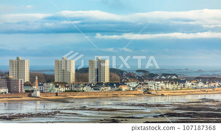 Saint Helier capital city panorama with buildings and residential houses on the La Manche seashore, in low tide, bailiwick of Jersey, Channel Islands, Great Britain 107187368