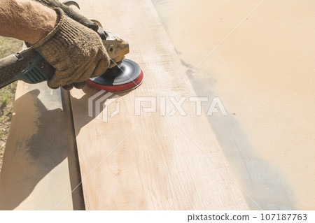 Grinding of an oak board with an angle grinder Grinding of an oak board with an angle grinder 107187763