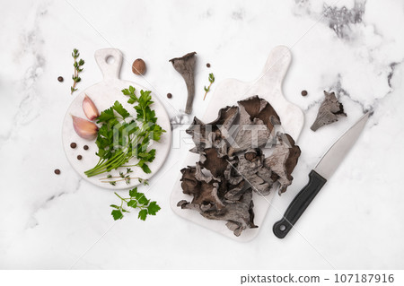Black chanterelle mushrooms ready for cooking. Craterellus cornucopioides, or horn of plenty trumpet or of the dead Black chanterelle mushrooms ready for cooking. Craterellus cornucopioides, or horn of plenty trumpet or of the dead 107187916