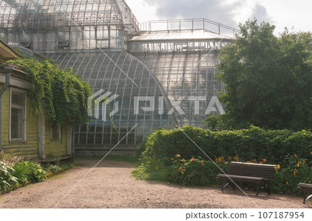 corner of an old botanical garden with a huge vintage greenhouse in the background corner of an old botanical garden with a huge vintage greenhouse in the background 107187954