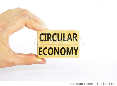 Circular economy symbol. Concept words Circular economy on beautiful wooden block. Beautiful white table white background. Businessman hand. Business circular economy concept. Copy space. 107188138