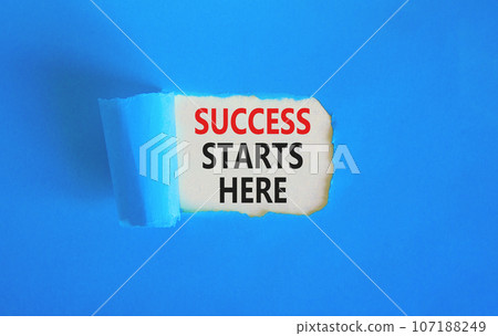 Success starts here symbol. Concept word Success starts here on beautiful white paper. Beautiful blue table blue background. Business motivational success starts here concept. Copy space. 107188249