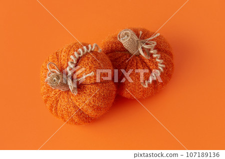 Autumn handmade textile decoration on orange table. Cozy fabric pumpkin. Thanksgiving decor. 107189136