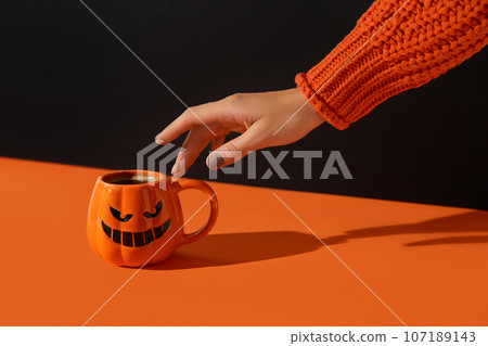 Cappuccino latte coffee in pumpkin cup on black orange background. Halloween celebration concept 107189143